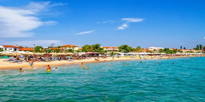 Nikiti Beach in Halkidiki, Greece with sandy shores, turquoise water, and pine forest backdrop
