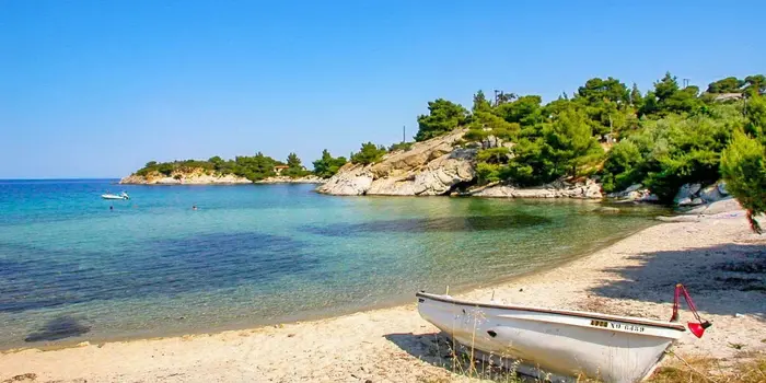 Spathies Beach in Sithonia, Greece with turquoise water, sandy shore, and pine trees