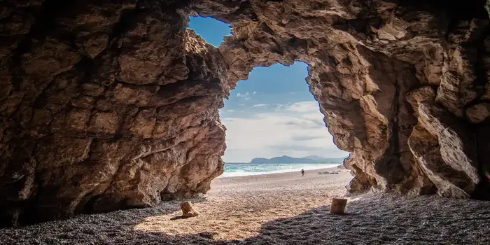 Traganou Beach in Rhodes, Greece with clear blue water, pebble shoreline, and rocky cliffs near Faliraki